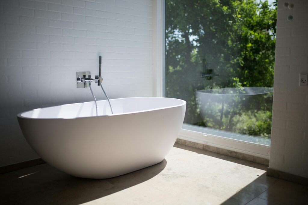Bath tub next to a window looking onto trees. Recycling is important